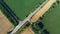 Automobile asphalt road with cars driving along it between agricultural fields