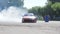Automobile drifting, bold driver slides over asphalt and makes lot of smoke under wheels