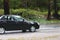 Automobile driving on the puddle on a highway