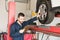 Automobile Engineer Examining Car Tire While Going Through Check