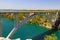 Automobile long high arched bridge over the Krka river in Croatia near Sibenik. Picturesque Croatian river landscape in