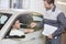 Automobile mechanic giving car key to female customer in workshop