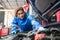 Automobile mechanic repairman checking the automotive engine part in the garage. Professional vehicle maintenance man fix the