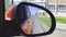 Automobile in motion. View in the rear view side mirror of a auto, driving a red car along the track