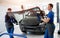 Automobile special workers replacing windscreen of a car in auto service