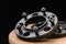 Automotive parts - close up new stainless black metal remote adapter spacer wheel hub of the car on black background