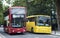 Automotive: Red public transport bus alongside a bright yellow private hire coach. 2