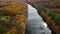 Autumn aerial tilt down river with colorful forest