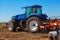 Autumn afternoon tractor rides and pulls the plow, plow a field after harvest of cereals - corn.