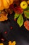 Autumn art composition - varied dried leaves, pumpkins, fruits, rowan berries on black background. Autumn, fall