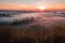 Autumn atmosphere. Dry grass in the foreground. Cold mist in the valley. The beauty of nature at sunrise.