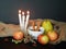 Autumn background with apples, pear, dried herbs, anise, cinnamon sticks, a cup of tea, candles, sackcloth.