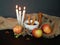 Autumn background with apples, pear, dried herbs, anise, cinnamon sticks, a cup of tea, candles, sackcloth.