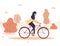 Autumn background. Cartoon arab woman in hijab ride on bicycle in park. Healthy lifestyle. Eco transportation. Modern