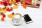 Autumn background, cup of cappuccino near mobile phone on wooden table.