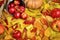 Autumn background, fruits and vegetables on yellow fallen leaves, apples and pumpkin, decoration in country style