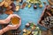 Autumn background with leaves, chestnuts, acorns, pine cone and woman hands holding hot cup of tea. Top view, flat lay. Copyspace.