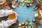 Autumn background with leaves, chestnuts, acorns, pine cone and woman hands in a sweater holding hot cup of tea. Top view, flat la