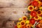 Autumn background with orange and yellow gerbera flowers, red berries, decorative pumpkins, wheat ears. Thanksgiving day