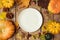 Autumn background with plate, fall leaves and pumpkin over wooden table.