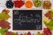 Autumn background. School board with the inscription Autumn. Berries and leaves of viburnum, sea buckthorn, blue and green grapes,