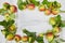 Autumn background of small apple and leaves on biege linen textile background. Empty space for text. Top view.