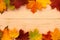 Autumn background. On a wooden board lie yellow leaves at the edges.