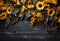 Autumn background with yellow sunflowers and leaves on dark wooden background