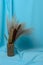 Autumn bouquet of cattails and reeds on a textured background made of soft blue fabric with elegant pleats