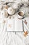 Autumn breakfast in bed composition. Blank open notebook mockup. Cup of coffee, white pumpkins, sweater, oak leaves and
