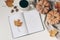 Autumn breakfast composition. Blank open notepad, diary mockup. Cup of coffee, pumpkins, plaid, maple leaves and acorns