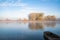 Autumn calm morning on meadow with a boat on the river. Beautiful sunrise over field with sunlight and mist