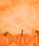 Autumn card of three orange doodle pumpkins on watercolor orange splashed background. Abstract warm hand drawn Thanksgiving card