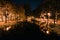 Autumn city park at night. Street lights and trees along the river.