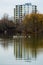 Autumn cityscape at lake, symmetrical reflections in water