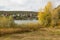 Autumn  cloudy river landscape with old castle and yellow trees