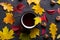 Autumn colorful  leafs and red cup of tea on dark  background