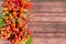 Autumn colorful still life of berries and fruits of mountain ash, red viburnum and rose hips on a hard surface.