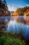 Autumn colors and clouds reflect in calm lake