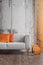 Autumn colors in wabi sabi living room interior with shabby wall and new stylish couch and magazine rack