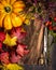 Autumn composing with foliage, pumpkin and vintage scissors on rustic wooden background