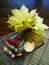 Autumn composition with bouquet of maple fall leaves, striped knitted gloves and burning candle on the table