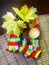 Autumn composition with bouquet of maple fall leaves, striped knitted gloves and burning candle on the table