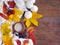 Autumn composition. Cup of coffee, colorful leaves and scarf on wooden background. Space for your text