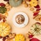 Autumn composition with cup of coffee latte, pumpkins, nuts and cinnamons on beige paper background