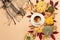 Autumn composition with cup of coffee, pumpkins, apples, nuts and cinnamons on pastel beige background
