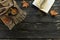 Autumn composition. Cup of coffee, scarf, open book, maple leaves on black wooden background with copy space, top view.