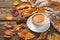 Autumn composition with a cup of coffee, a sweater and leaves on a brown, wooden background.