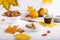 Autumn composition with cup of hot drink, delicious apple strudel   and colorful fall leaves on white background. Copy space.