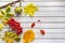 Autumn composition of fallen leaves of maple, mountain ash, chestnut on white wooden background